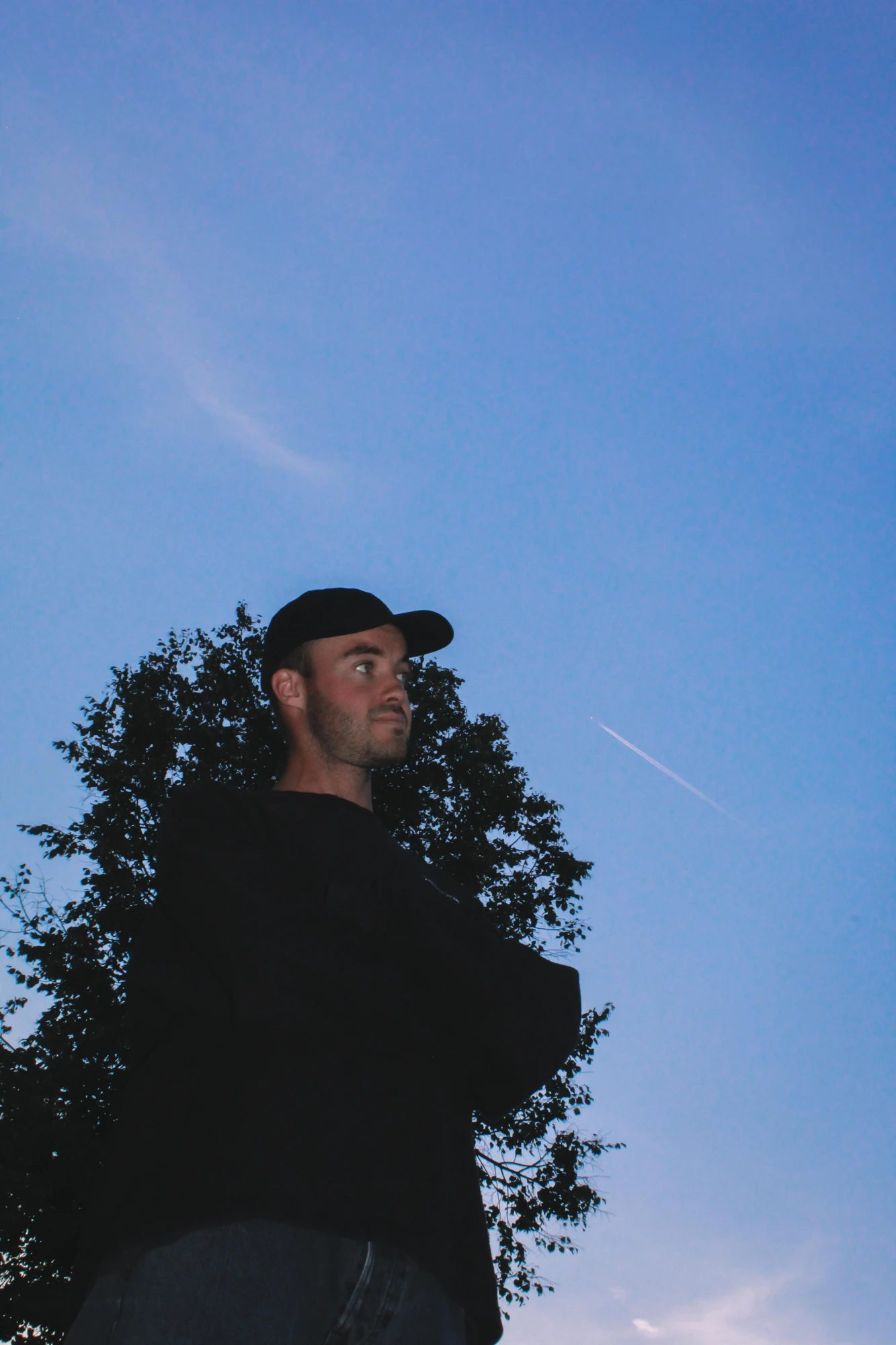 Portrait eines Mannes mit Cap vor blauem Abendhimmel
